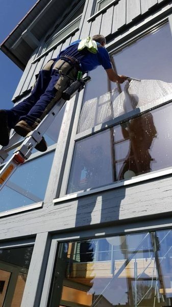 Glasreinigung an Außenfenstern mit Leiter