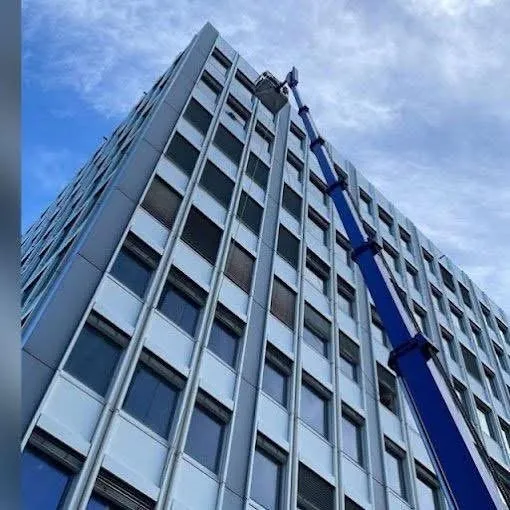 Fassadenreinigung an einem Hochhaus mit Spezialkran